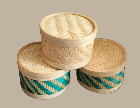 Three woven bamboo containers with lids on a cream baground